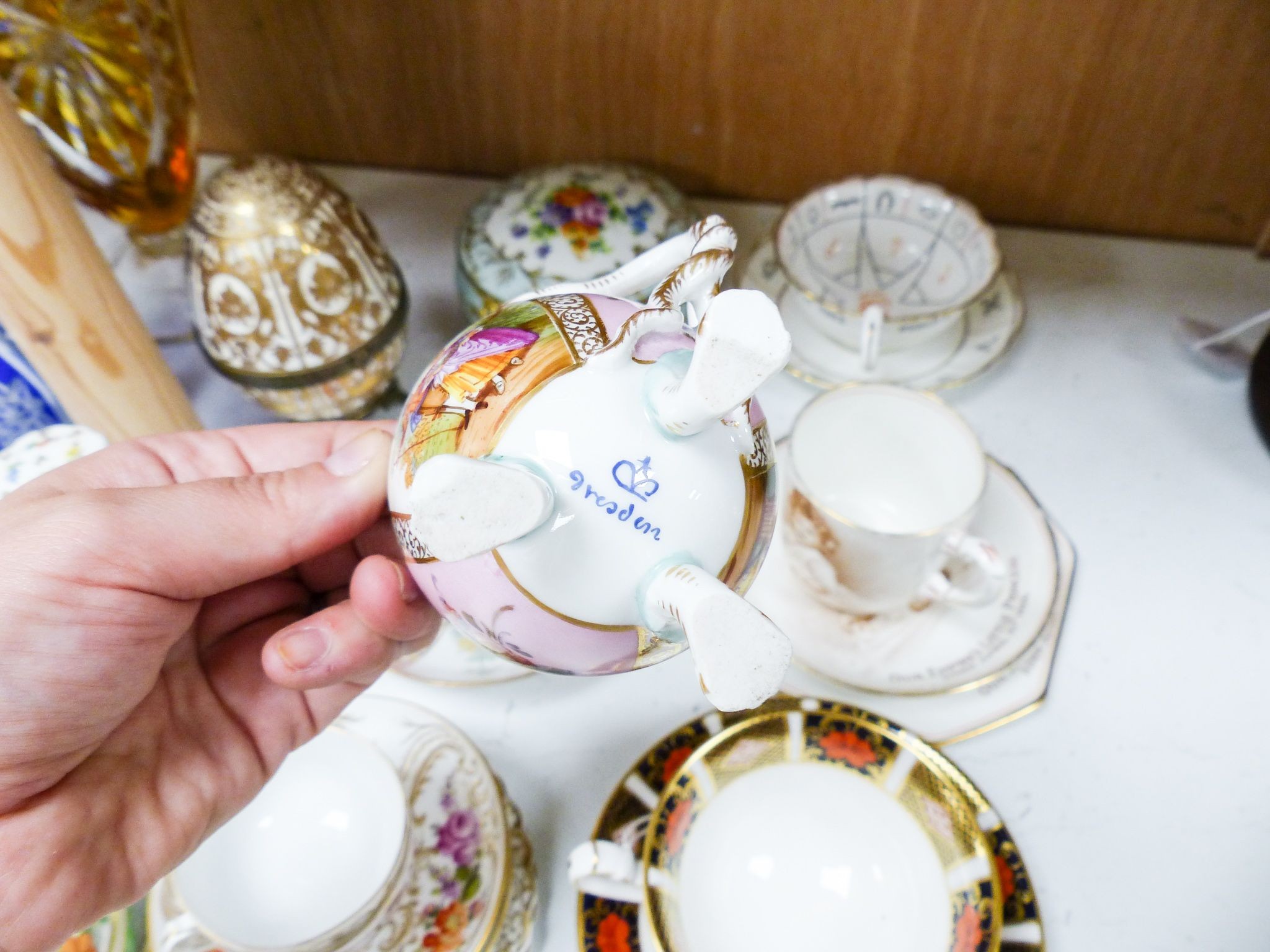 A group of Dresden and Continental porcelain cups and saucers boxes and covers and a scent bottle, 14 cm high